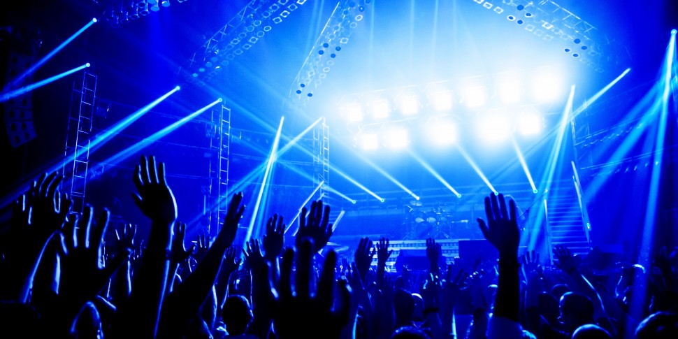 20924727 - rock concert, crowd of young people enjoying night performance, raised up and clapping hands, dance club, bright blue lights, music entertainment